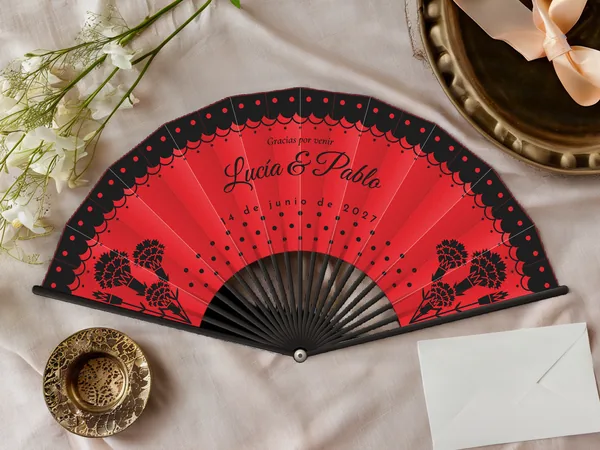 Abanico de boda personalizado «Flamenco», tela rojo e impresión en negro, sobre una mesa de boda