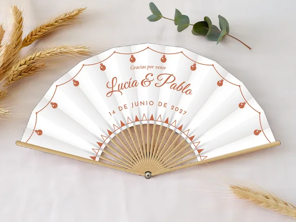 Abanico de boda personalizado «Verbena», tela blanco e impresión en terracota, sobre una mesa de boda