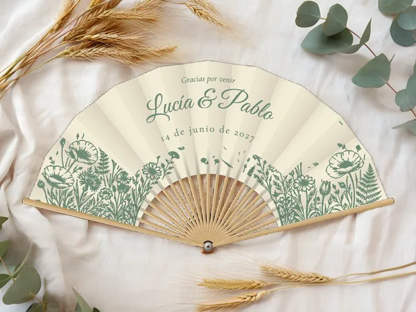 Abanico de boda personalizado «Jardín campestre», tela marfil e impresión en verde salvia, sobre una mesa de boda