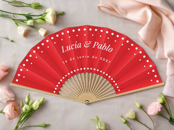Abanico de boda personalizado «Lunares», tela rojo e impresión en blanco, sobre una mesa de boda