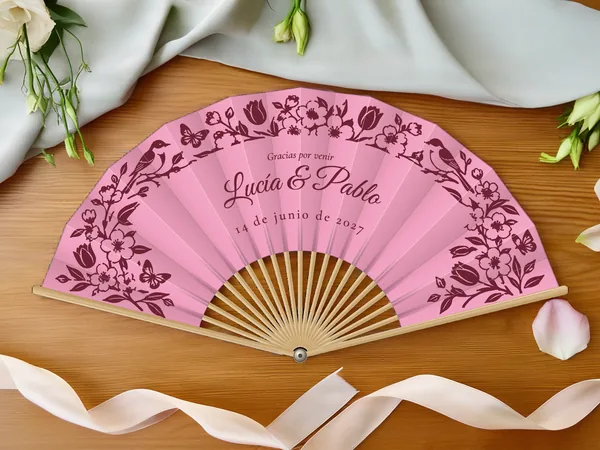 Abanico de boda personalizado «Primavera en flor», tela rosa e impresión en burdeos, sobre una mesa de boda